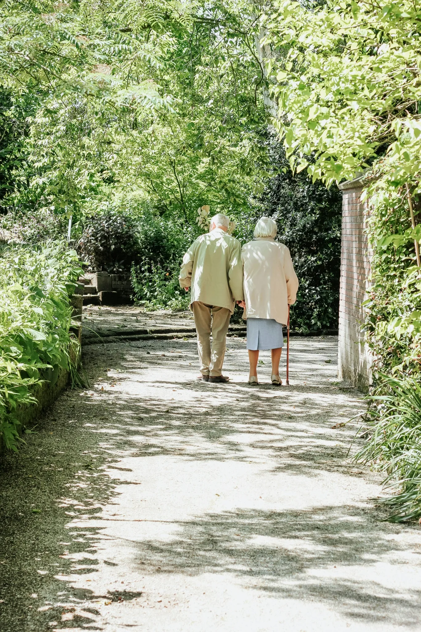 An older couple walking together outdoors, representing independence and familiar routines